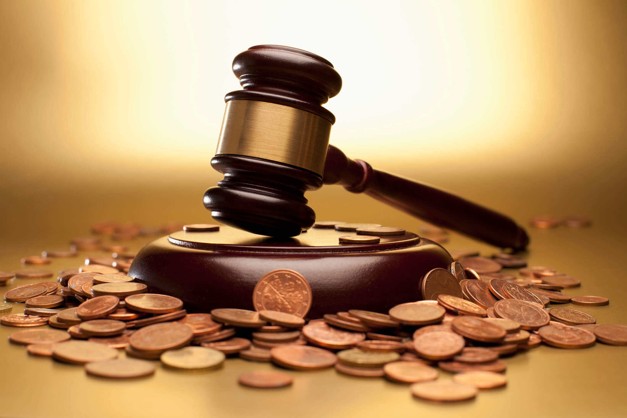 An auctioneers hammer surrounded by coins